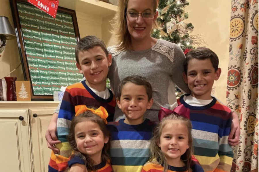 Mom smiling with her five small children in front of the Christmas tree