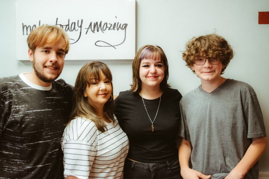 Mom with her two sons and daughter smiling at the camera