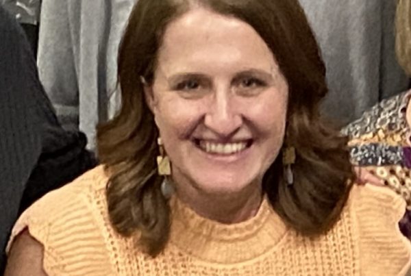 Female in yellow shirt smiling in a group photo
