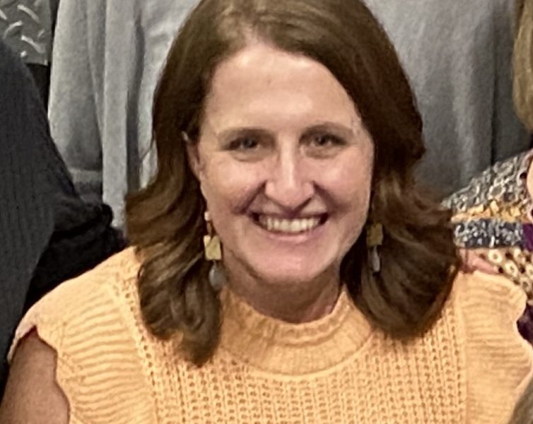 Female in yellow shirt smiling in a group photo