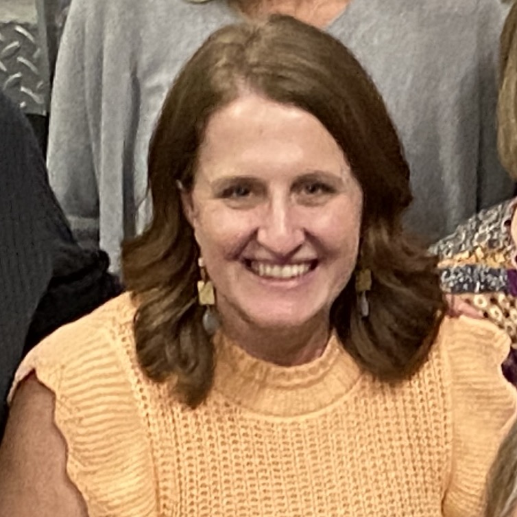 Female in yellow shirt smiling in a group photo