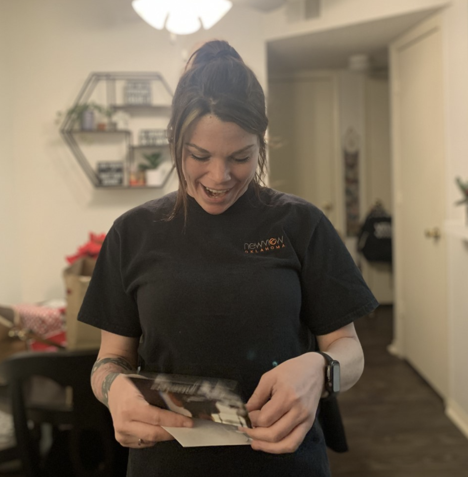 Young Women smiling with surprise as she opens an envelope containing a thank you card and gift card